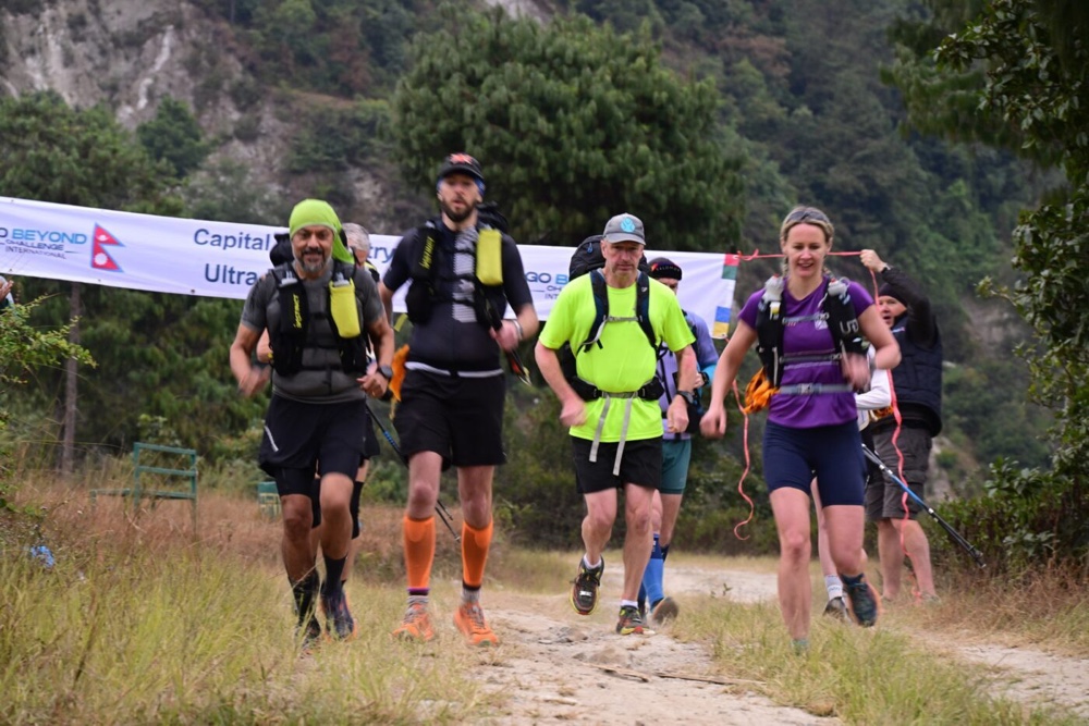 A group of people running on a dirt pathDescription automatically generated